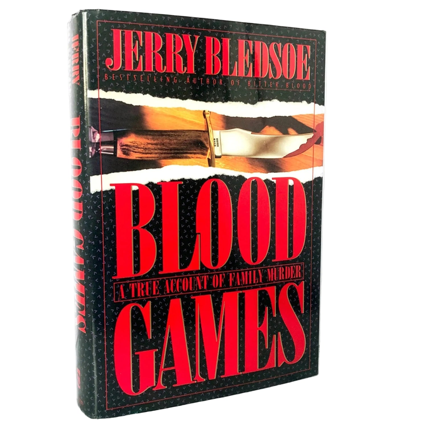 The book 'Blood Games' by Jerry Bledsoe, featuring a black cover with bold red title text and a knife graphic, standing upright on a light marble surface against a white background.
