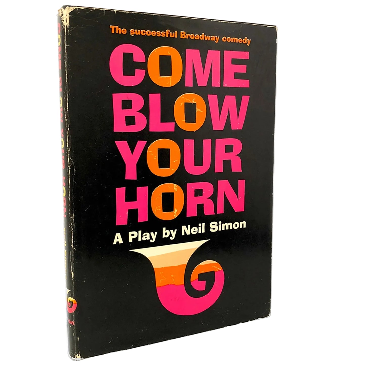 A vintage hardcover book of Neil Simon's Broadway play 'Come Blow Your Horn' standing upright on a light marble surface against a white background.