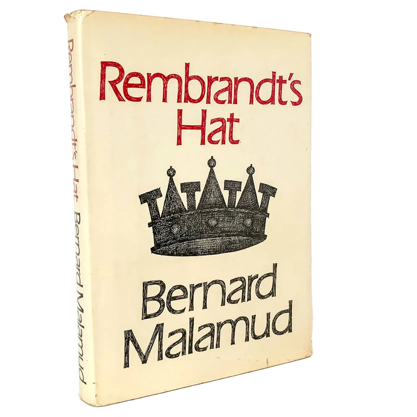 Vintage paperback book of 'Rembrandt's Hat' by Bernard Malamud, featuring a cream-colored cover with red title text and a black crown illustration, standing on a marble surface against a white background.