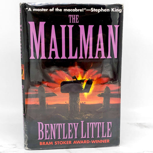 The cover of 'The Mailman' book by Bentley Little features a silhouette of a mailman with a dark, ominous background. The book is a horror novel and has won a Bram Stoker Award.