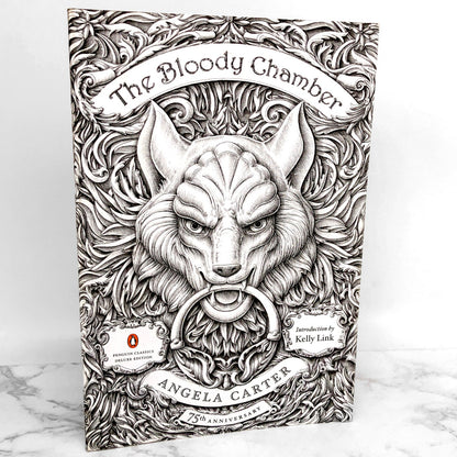 A paperback edition of 'The Bloody Chamber & Other Stories' by Angela Carter, featuring a black and white illustration of a wolf's head on the cover.