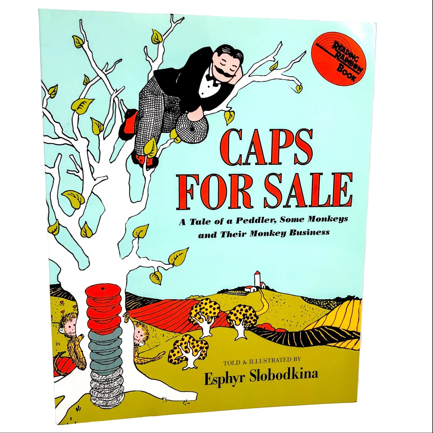 Cover of the book 'Caps for Sale' featuring an illustration of a peddler with a monkey on his cap, with a red and yellow color scheme and the Reading Rainbow logo.